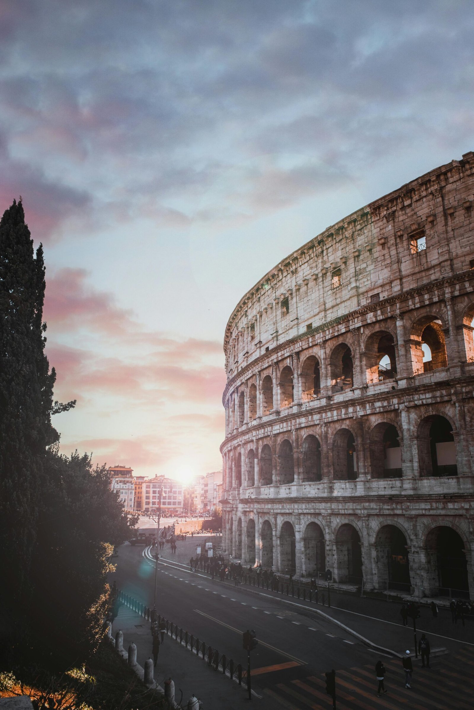 Scenic view of the iconic Colosseum in Rome at sunset, showcasing ancient architecture.